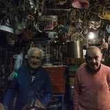 I fratelli Martinelli nel piccolo spazio di lavoro della bottega, sommersa da oggetti di metallo di ogni foggia